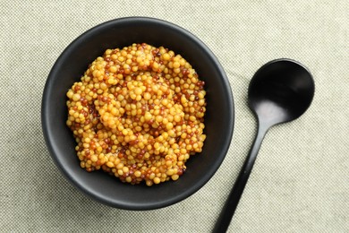 Photo of Whole grain mustard in bowl and spoon on light table, flat lay