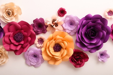 Photo of Beautiful paper flowers on white wall. Interior element
