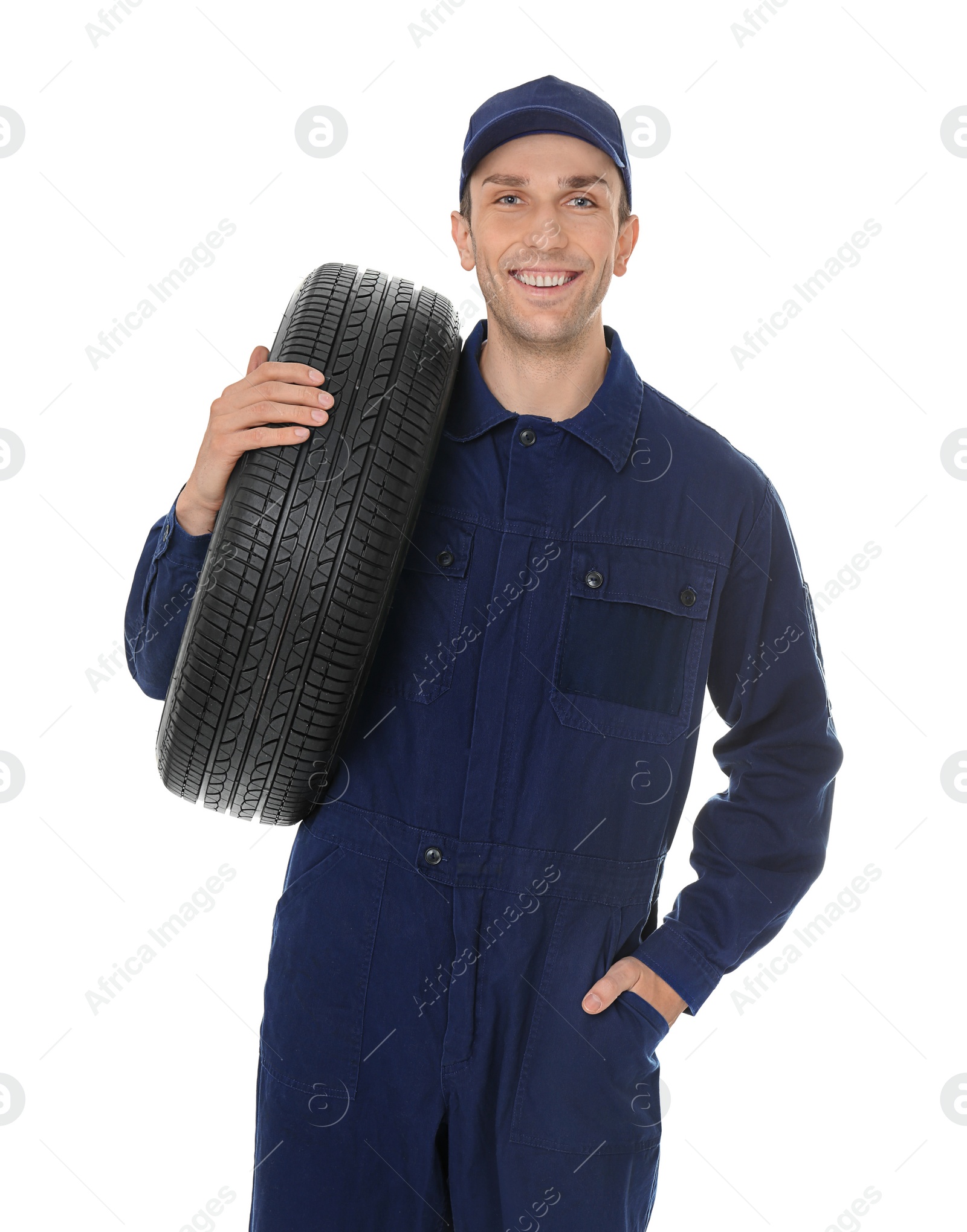 Photo of Young mechanic in uniform holding car tire on white background