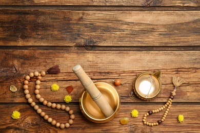 Photo of Flat lay composition with golden singing bowl on wooden table, space for text. Sound healing