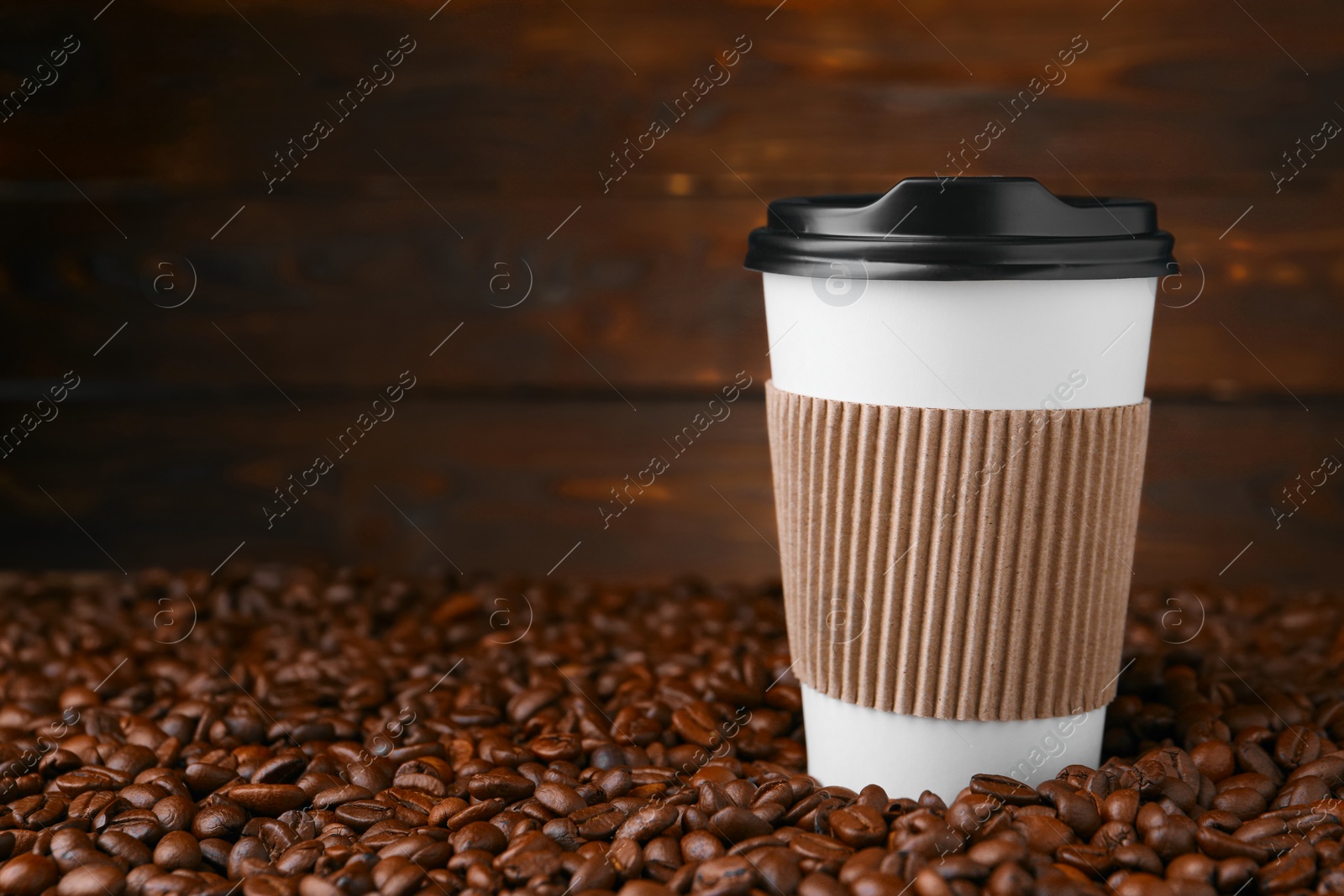 Photo of Coffee to go. Paper cup and roasted beans against wooden background, space for text