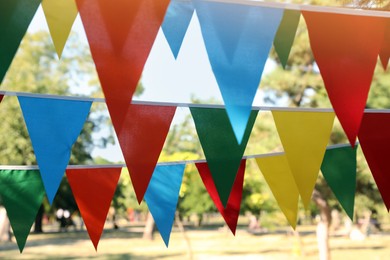 Photo of Colorful bunting flags in park. Party decor