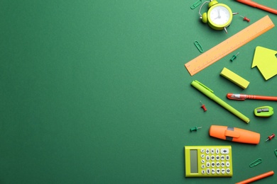 Photo of Bright school stationery on green background, flat lay. Space for text