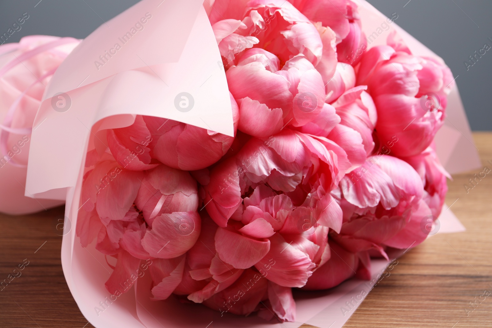 Photo of Bouquet of beautiful pink peonies on wooden table, closeup