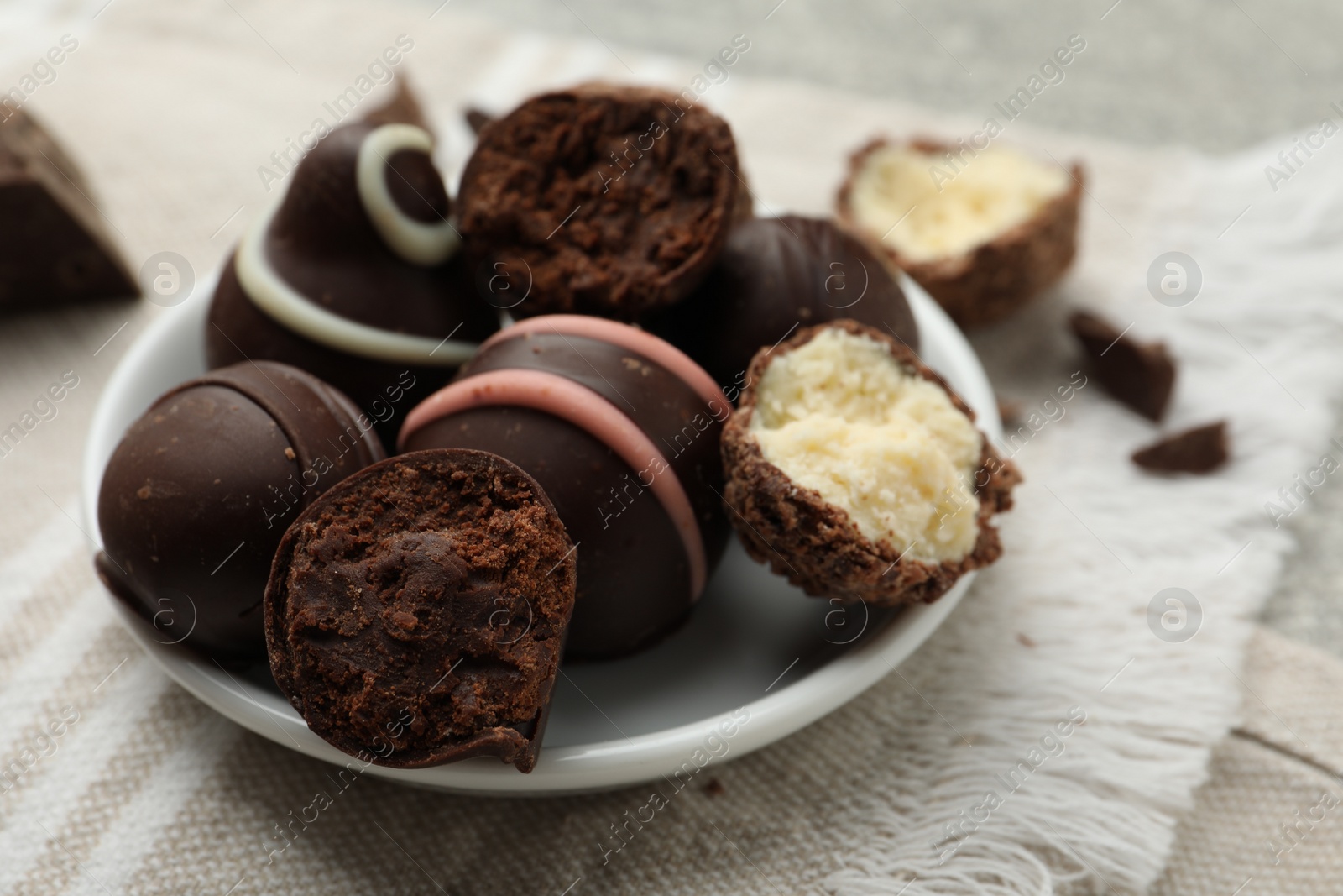 Photo of Many different delicious chocolate truffles on kitchen towel