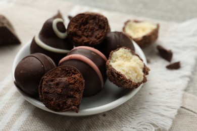 Photo of Many different delicious chocolate truffles on kitchen towel