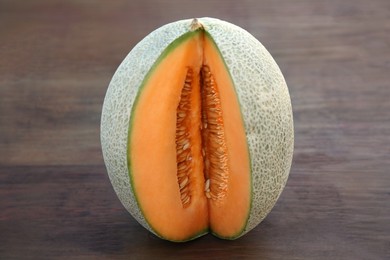 Photo of Cut delicious ripe melon on wooden table, closeup