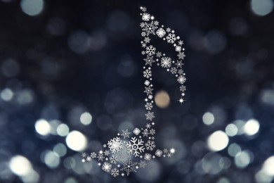 Image of Music note made of snowflakes on dark background. Bokeh effect