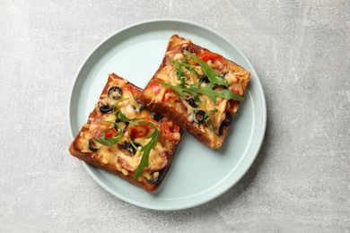 Tasty pizza toasts served on grey table, top view