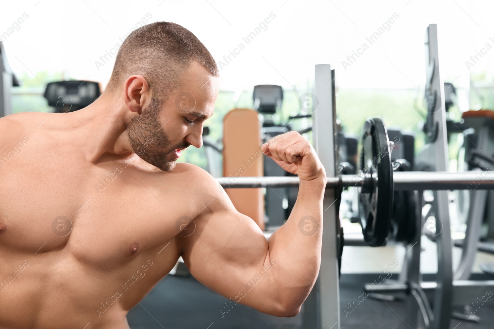 Photo of Shirtless strong young man posing in gym