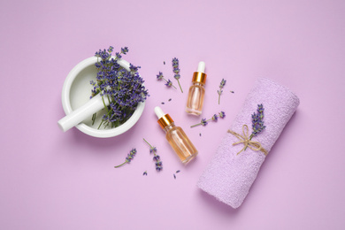 Photo of Flat lay composition with lavender flowers and natural essential oil on pink background