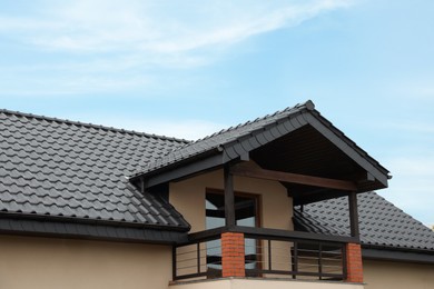 Photo of Beautiful house with grey roof against blue sky