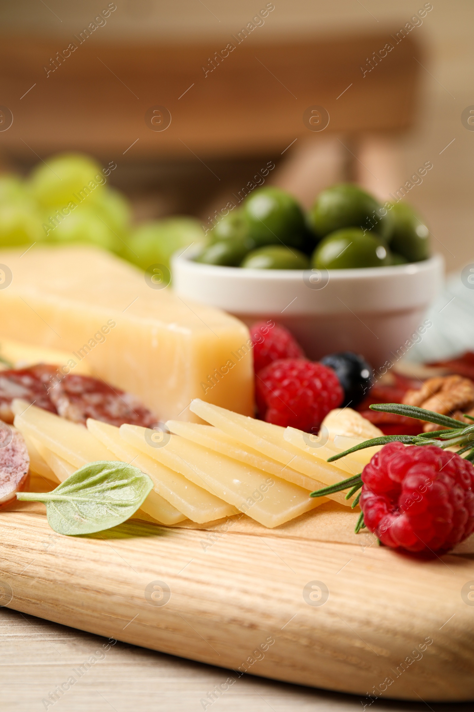 Photo of Snack set with delicious Parmesan cheese on wooden board, closeup