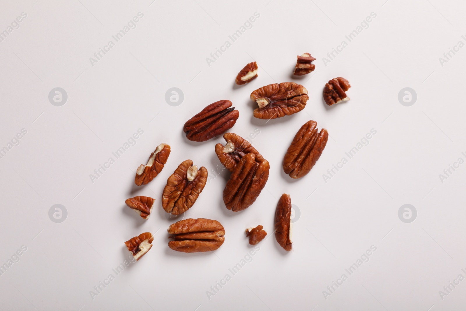 Photo of Delicious pecan nuts on white background, flat lay