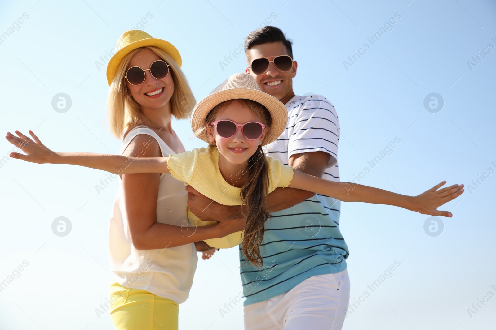 Photo of Parents playing with daughter at beach. Family vacation