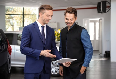 Young car salesman working with client in dealership