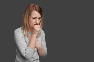 Photo of Young woman coughing on grey background