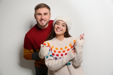 Photo of Young couple in warm sweaters on white background