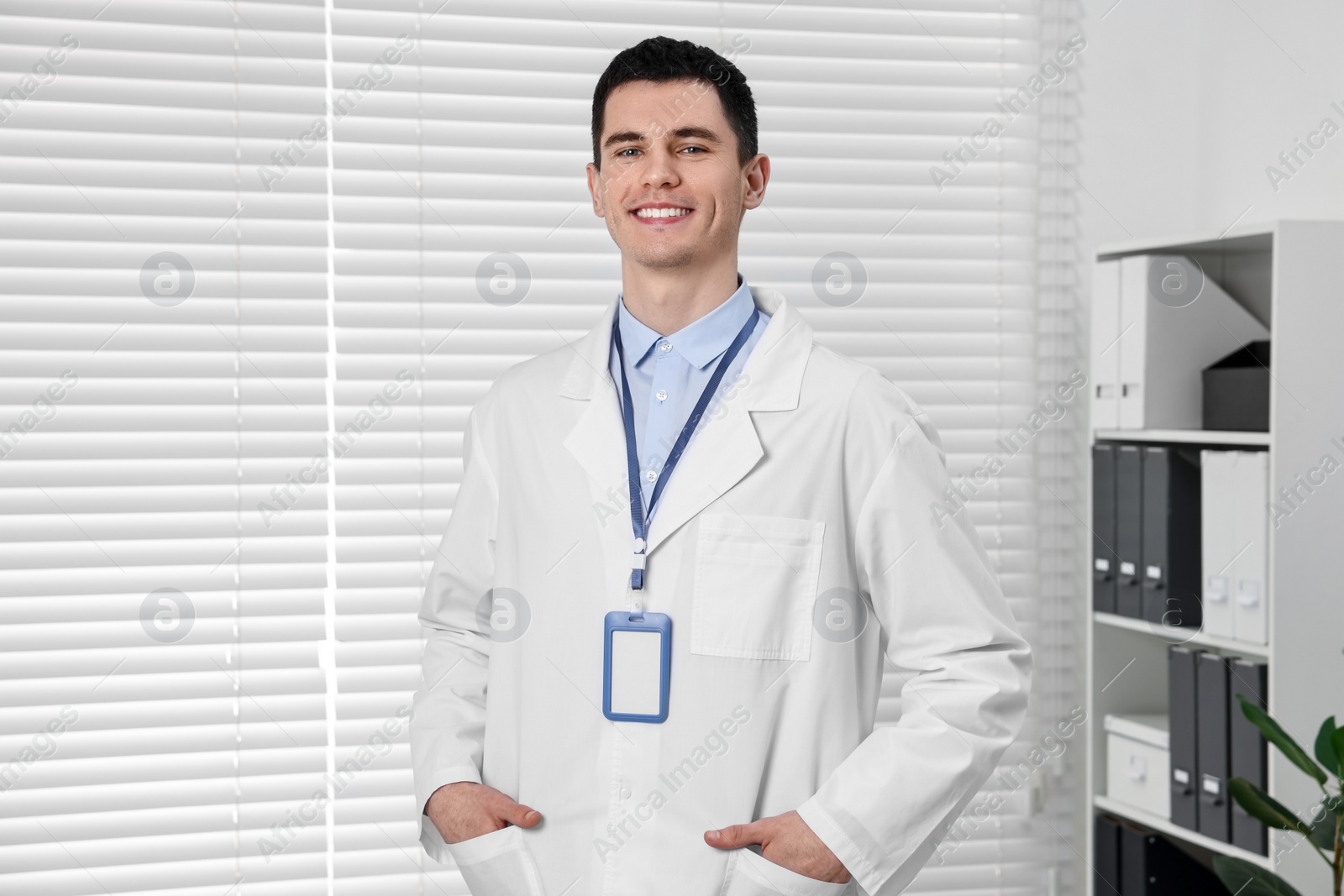 Photo of Smiling doctor with empty badge in hospital