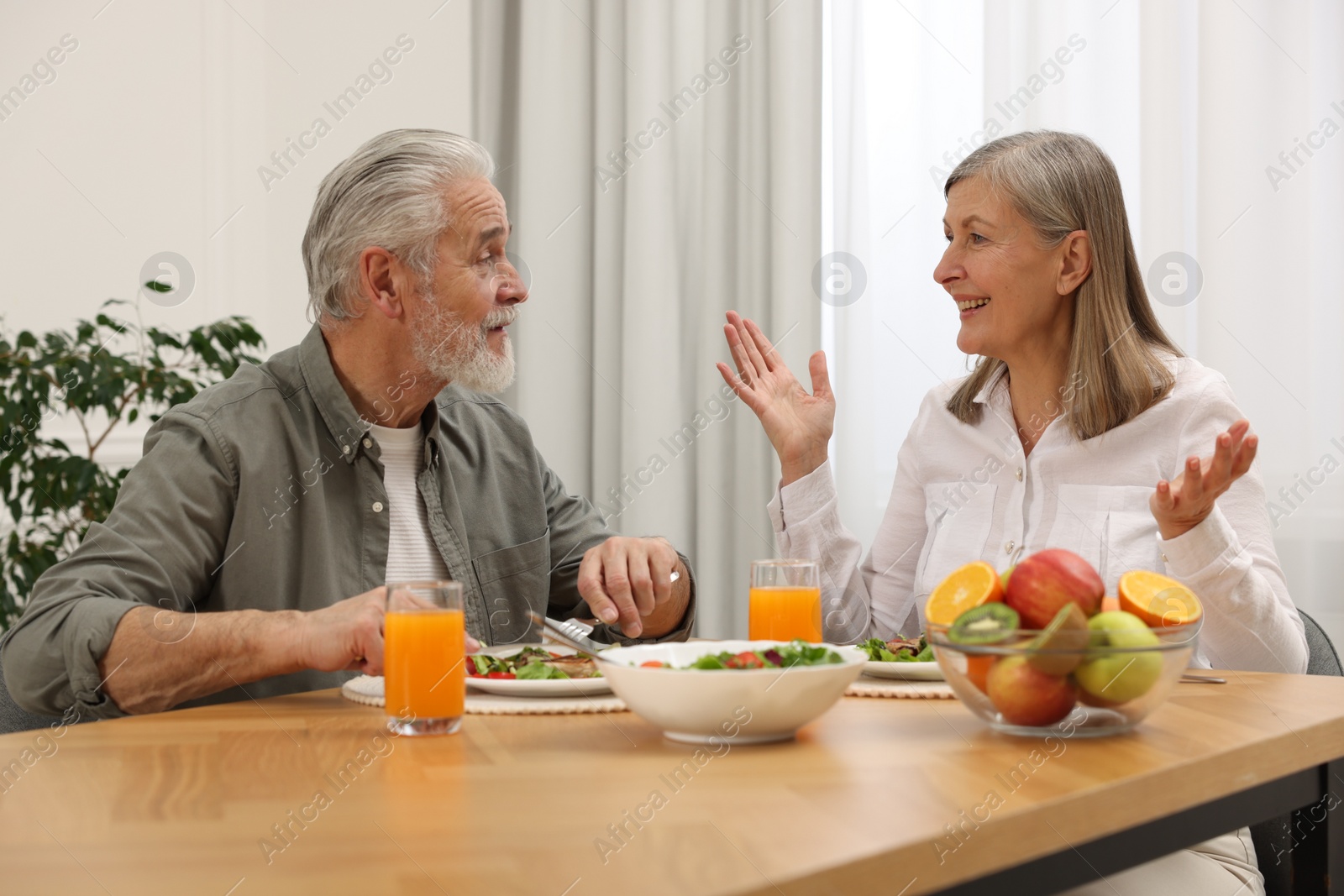 Photo of Happy senior couple having dinner at home