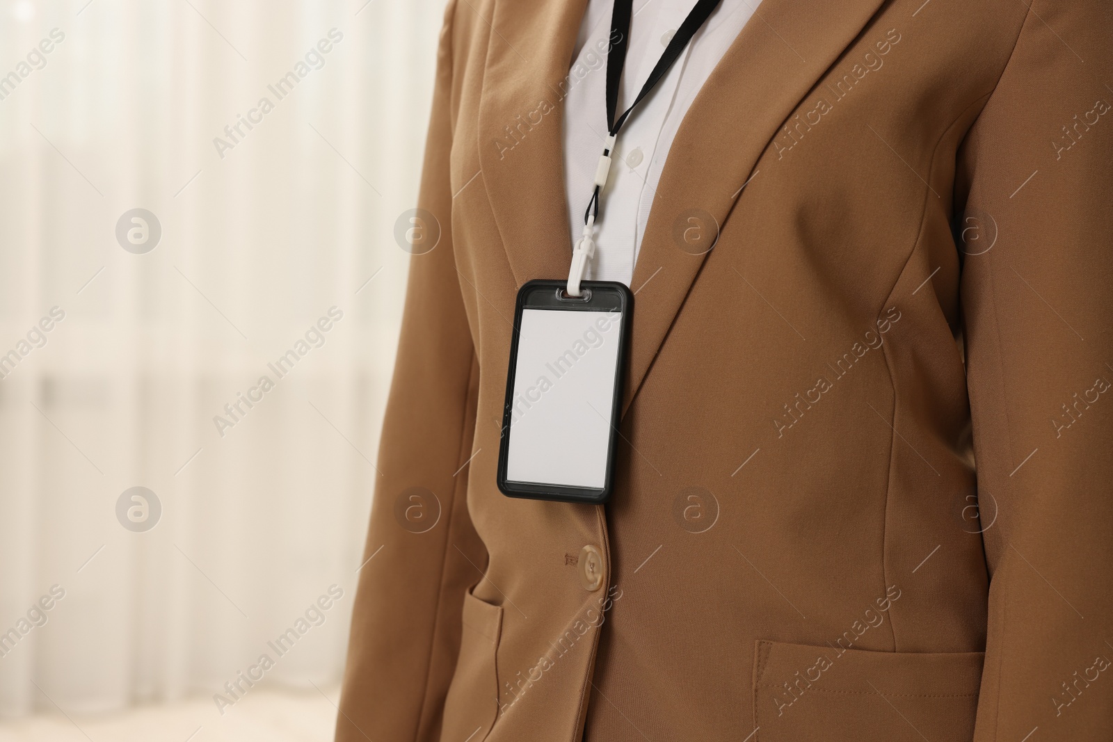 Photo of Woman with blank badge indoors, closeup. Space for text