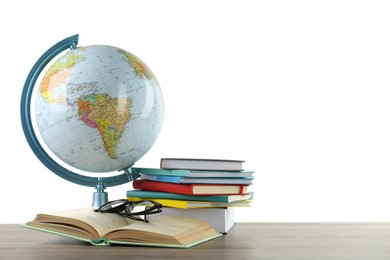 Globe, books and eyeglasses on wooden table against white background. Geography lesson
