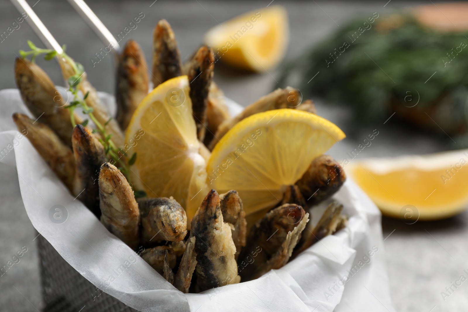 Photo of Delicious fried anchovies with slices of lemon, closeup view