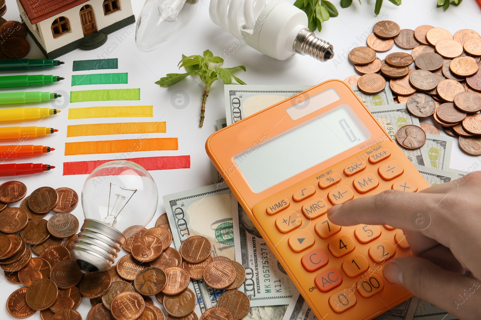 Photo of Woman counting on calculator at table, closeup. Energy efficiency concept