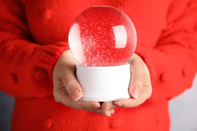 Woman holding magical empty snow globe, closeup