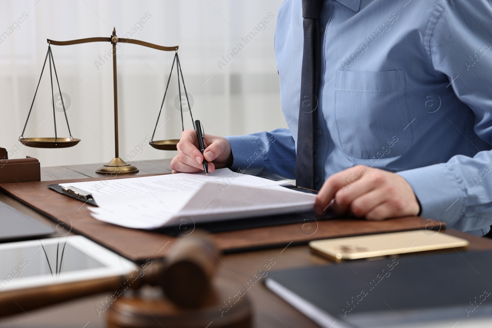 Photo of Lawyer working with documents at table indoors, closeup