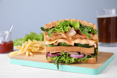 Photo of Tasty sandwich with chicken, ham and bacon served on white wooden table