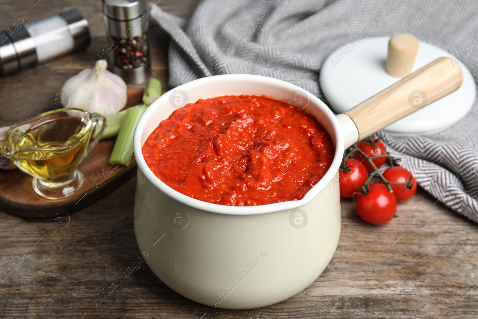 Photo of Pan of tomato sauce on wooden table