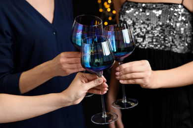 Photo of Women clinking glasses of red wine at party, closeup