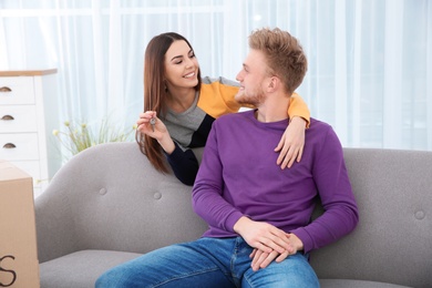 Young couple with key from their new house indoors. Moving day