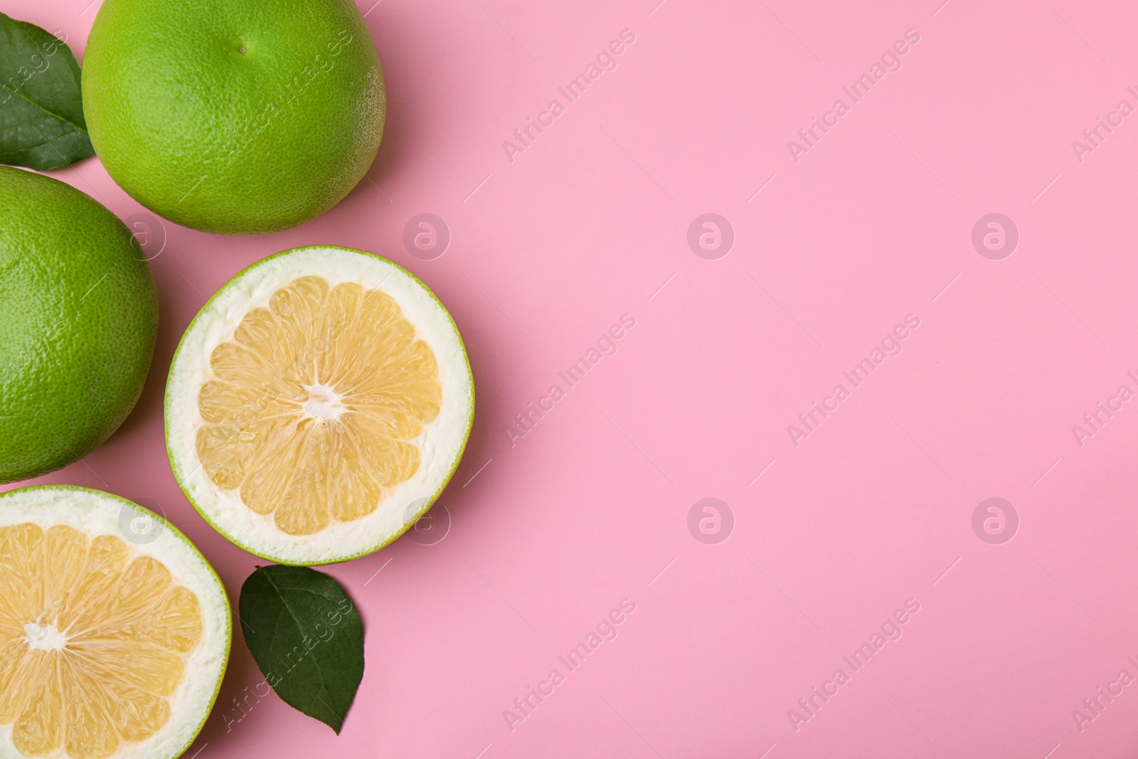 Photo of Tasty whole and cut sweeties on pink background, flat lay. Space for text