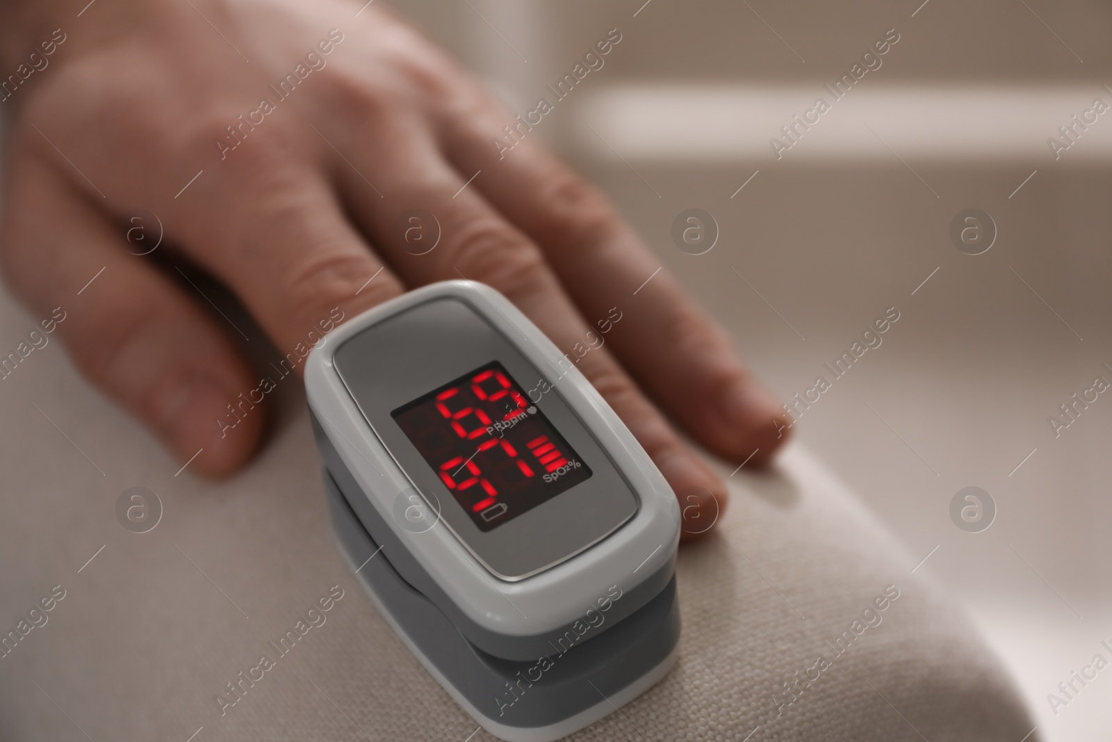 Photo of Man measuring oxygen level with modern fingertip pulse oximeter indoors, closeup. Space for text