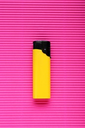 Stylish small pocket lighter on pink corrugated fiberboard, top view