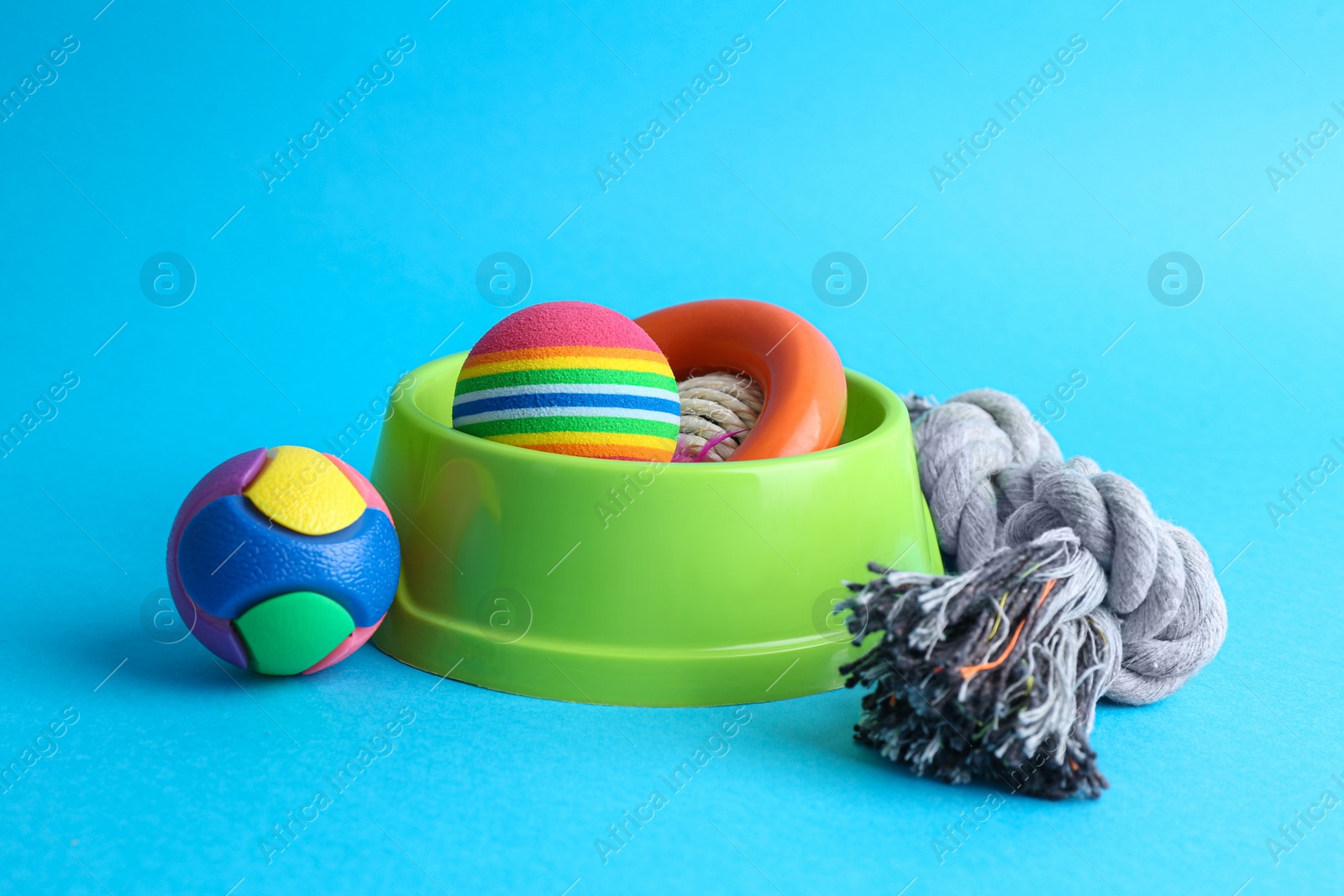 Photo of Pet toys and feeding bowl on light blue background