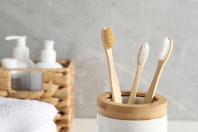 Photo of Holder with bamboo toothbrushes in bathroom, closeup. Space for text
