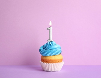 Photo of Birthday cupcake with number one candle on violet background