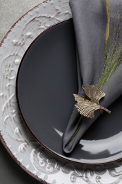 Photo of Fabric napkin and decorative ring for table setting on gray plate, top view