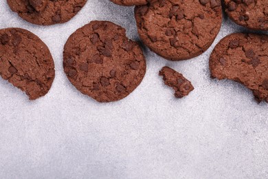 Tasty chocolate cookies on light grey textured table, flat lay. Space for text