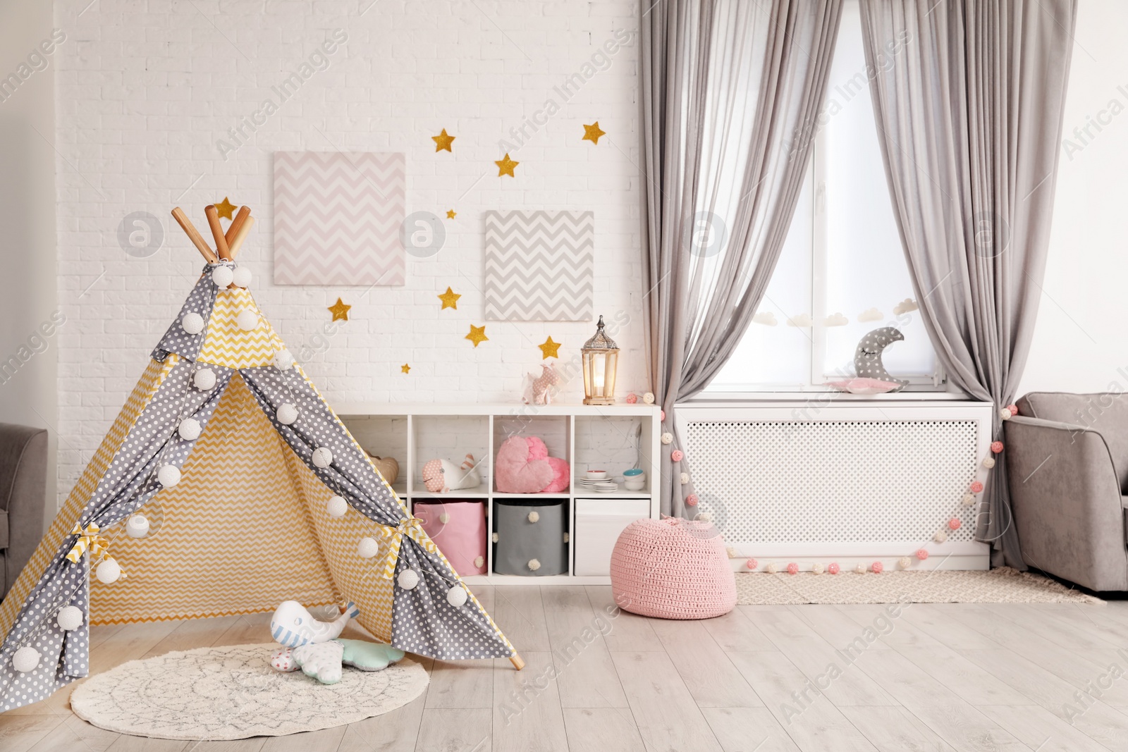 Photo of Cozy kids room interior with play tent and toys