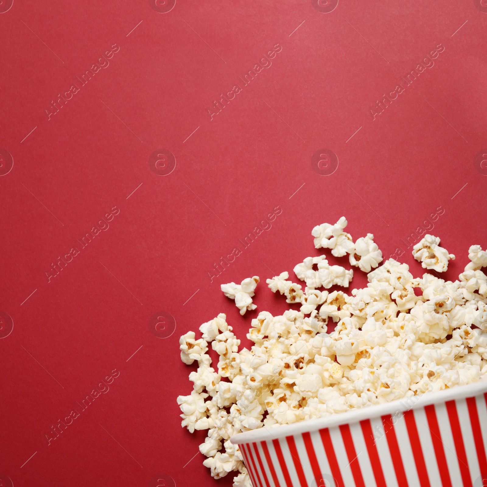 Photo of Delicious popcorn on red background, top view. Space for text