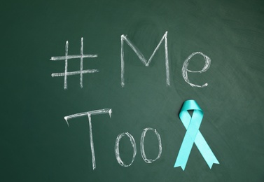 Photo of Teal ribbon and phrase #METOO written on green chalkboard, top view