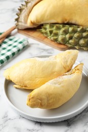 Photo of Plate with fresh ripe durian on white marble table
