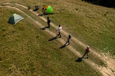 Image of Group of tourists near tents in campsite, aerial view. Drone photography