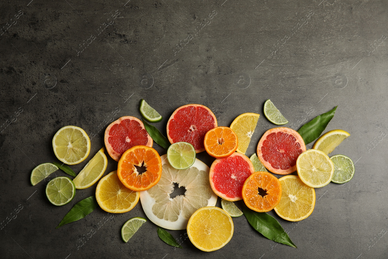 Photo of Different citrus fruits on grey background, top view. Space for text