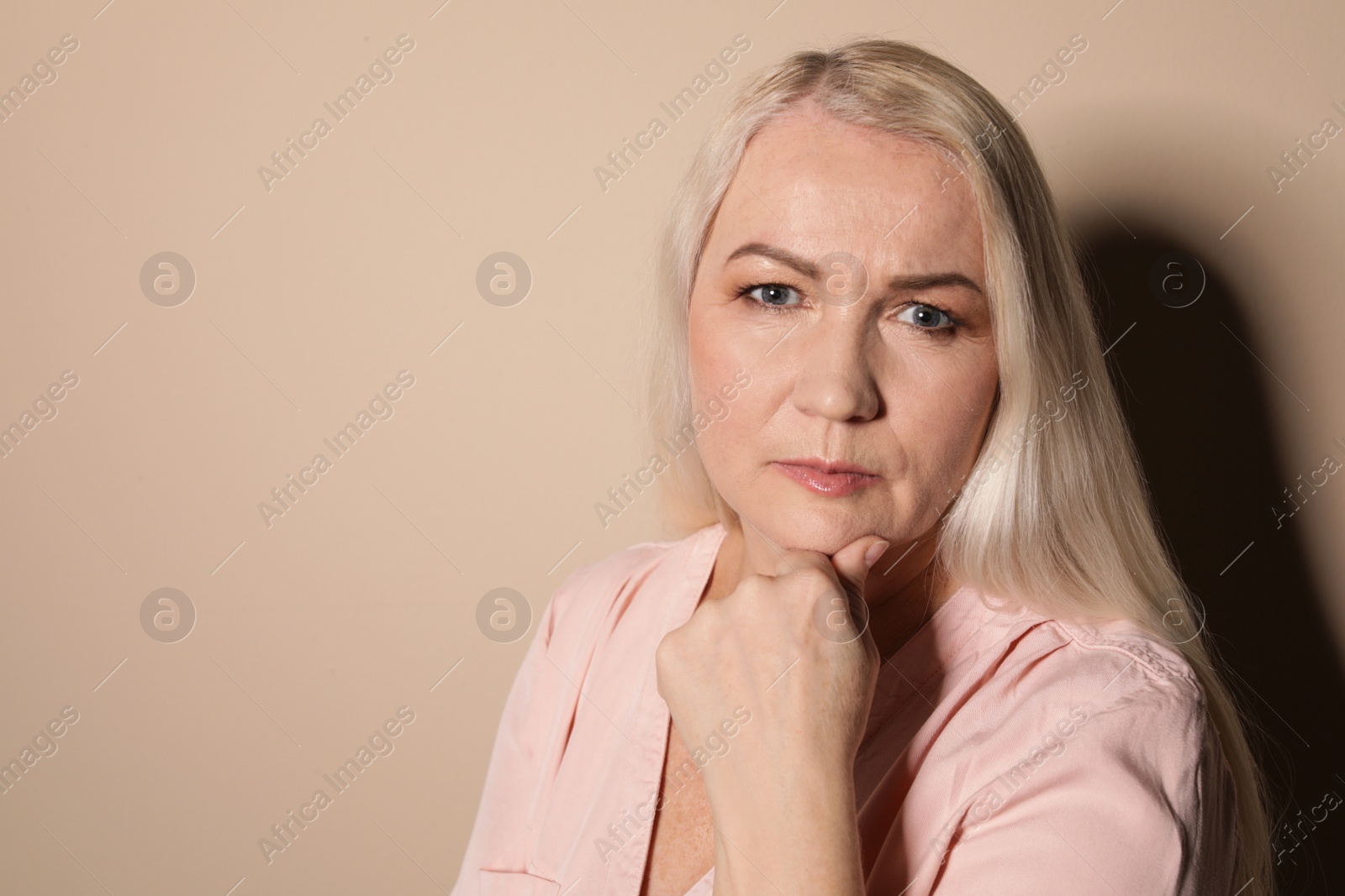 Photo of Portrait of mature woman on color background. Space for text