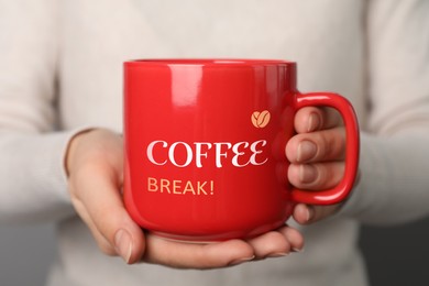 Woman holding mug with inscription Coffee Break, closeup